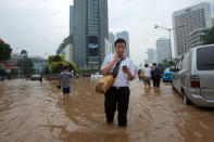 People wade through floodwaters in Jakarta's central business district on January 17, 2013 in Jakarta, Indonesia. Thousands of Indonesians were displaced and the capital was covered in many key areas in over a meter of water after days of heavy rain. (Photo by Ed Wray/Getty Images)