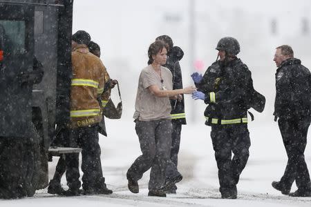 Police officers and fire department personnel lead people who were in a Planned Parenthood center out of an armored vehicle, after reports of an active shooter in Colorado Springs, Colorado November 27, 2015. REUTERS/Isaiah J. Downing