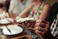 In this March 20, 2017 photo a tourist makes his own "empanada" during an activity called "The Argentine Experience" in Buenos Aires, Argentina. Tourists participating in "The Argentine Experience" have the chance to learn about the local cuisine, wine and traditions during a dinner in Buenos Aires. (AP Photo/Natacha Pisarenko)