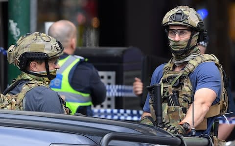 Armed security personnel stand near the Bourke Street mall in central Melbourne - Credit: AAP/James Ross/via REUTERS