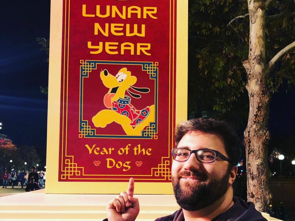 man pointing to a lunar new year sign at disneyland