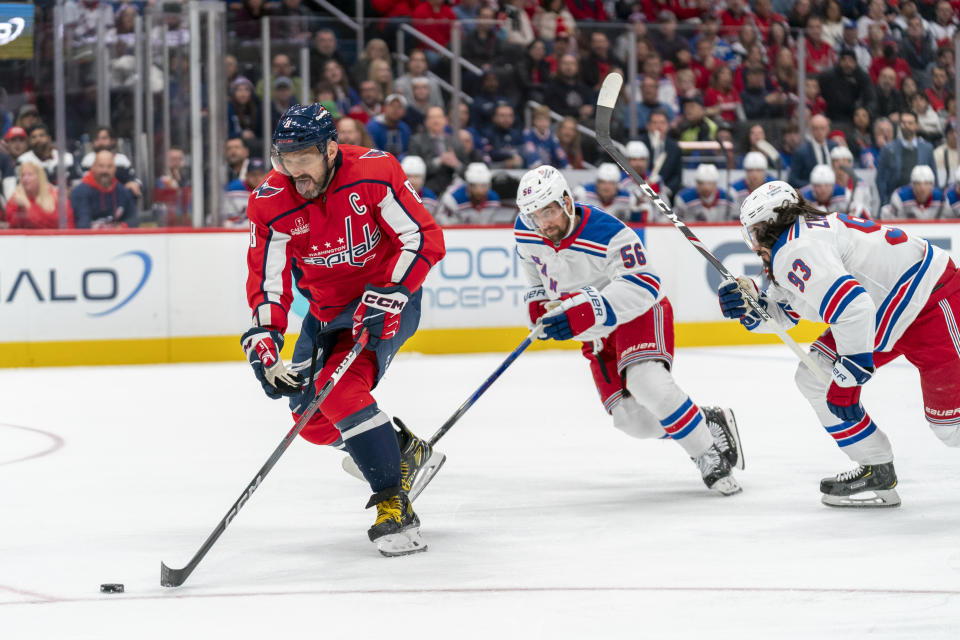 Washington Capitals left wing Alex Ovechkin (8) advances toward the net in front of New York Rangers defenseman Erik Gustafsson (56) and Rangers center Mika Zibanejad (93) during the first period of an NHL hockey game, Saturday, Dec. 9, 2023, in Washington. (AP Photo/Stephanie Scarbrough)