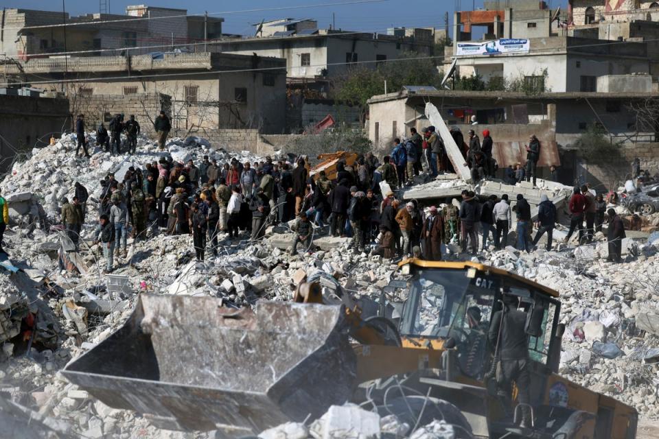 Des sauveteurs et des habitants fouillent les décombres de bâtiments effondrés dans la ville de Harem près de la frontière turque, province d'Idlib, Syrie (Copyright 2023 The Associated Press. Tous droits réservés)