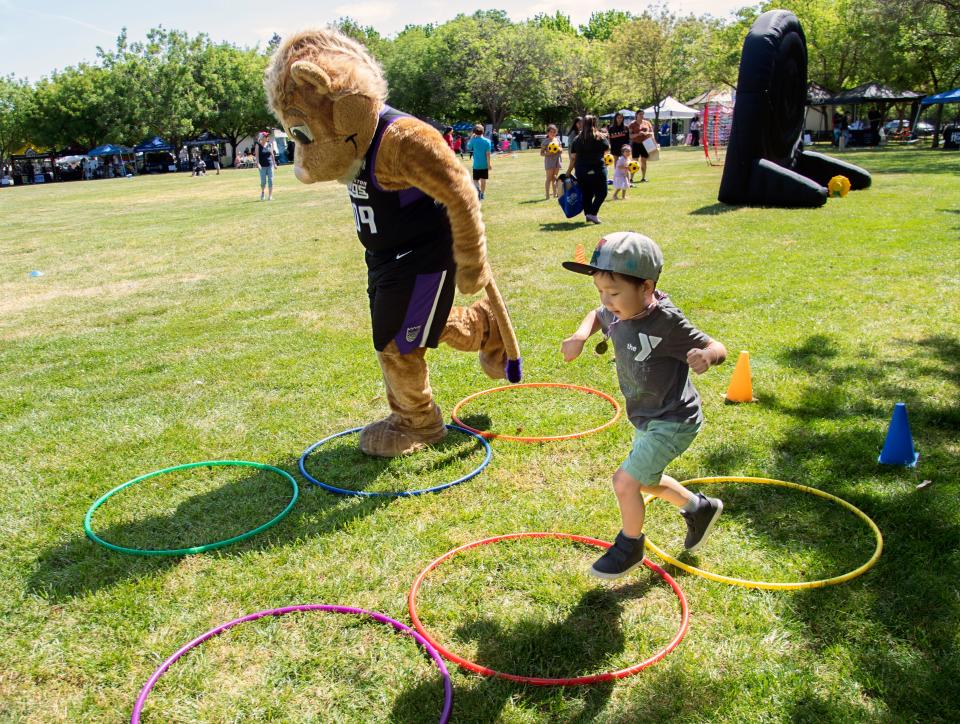 Stockton Kings mascot Dunkston runs through an obstacle course with 4-year-old Kaiden Saelee at the YMCA of San Joaquin County's Healthy Kids day at the Weber Point Events Center in downtown Stockton on Saturday Apr. 29, 2023. The free event was a part of the YMCA's national initiative to improve the health and well-being of kids and families.