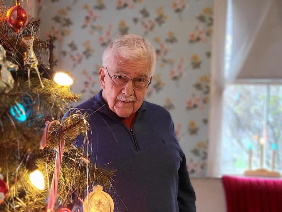 Sherm Pridham decorates a tree on Nov. 30 before Strawbery Banke Museum's tour of the Shapley-Drisco Pridham House on Puddle Lane. The name "Pridham" was added in October. Pridham and his family lived in the house during the 1940s and 1950s. The museum issued this statement: "Together with Strawbery Banke, Sherm remains dedicated to preserving and sharing the stories, including urban renewal and the displacement of many families from the Puddle Dock neighborhood."