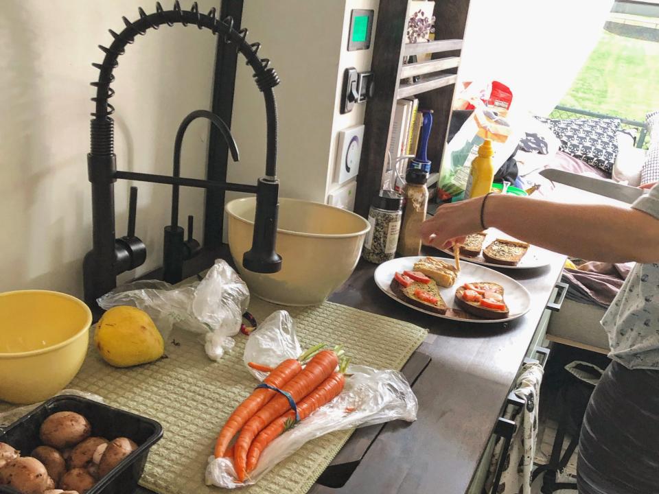 Carrots, vegetables, and cutting boards on wooden counter inside a van