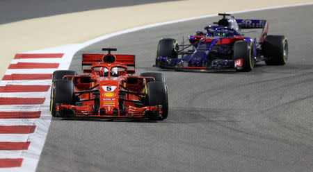 Formula 1 F1 - Bahrain Grand Prix - Bahrain International Circuit, Sakhir, Bahrain - April 8, 2018 Ferrari's Sebastian Vettel and Toro Rosso's Brendon Hartley in action during the race REUTERS/Ahmed Jadallah