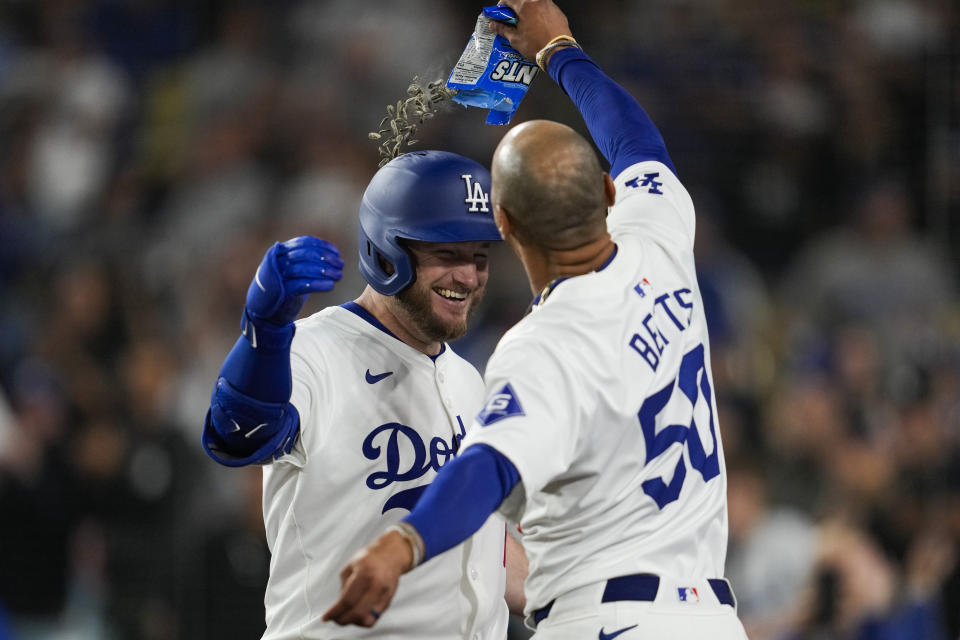 Los Angeles Dodgers' Max Muncy celebrates with Mookie Betts (50) after hitting a home run during the eighth inning of a baseball game against the Atlanta Braves in Los Angeles, Saturday, May 4, 2024. (AP Photo/Ashley Landis)