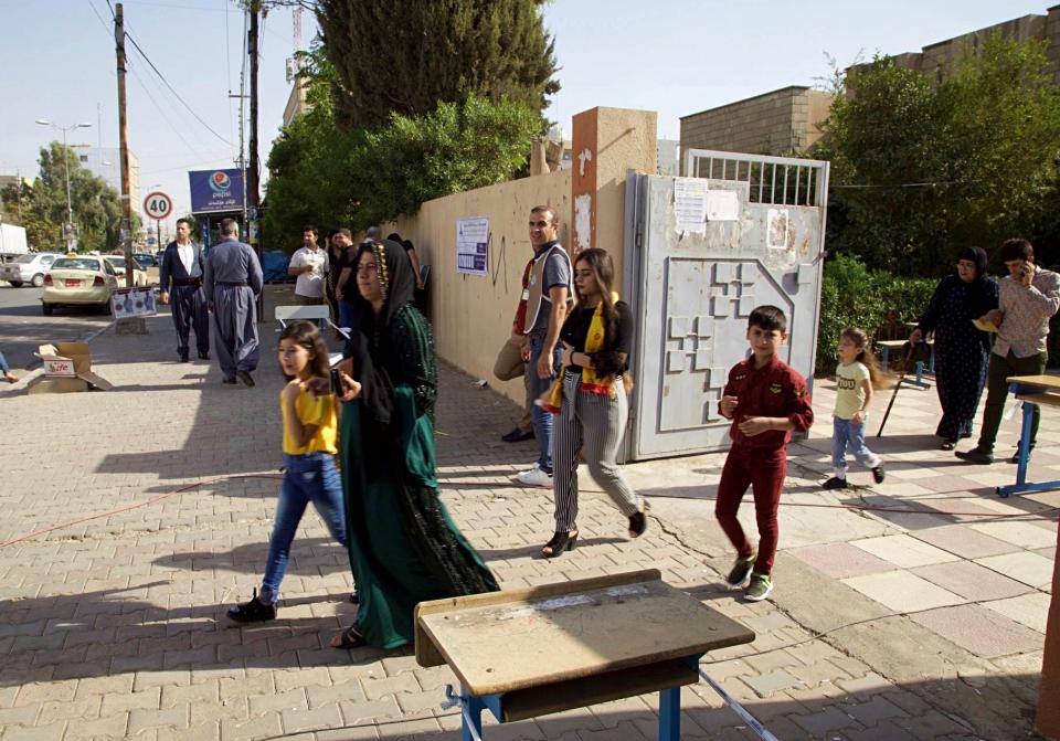 Iraqi Kurds leave a polling center after participating in parliamentary elections in Irbil, Iraq, Sunday, Sept. 30, 2018. Iraq's self-ruled Kurdish region held long-delayed parliamentary elections on Sunday, a year after a vote for independence sparked a punishing backlash from Baghdad, leaving Kurdish leaders deeply divided. (AP Photo/Salar Salim)