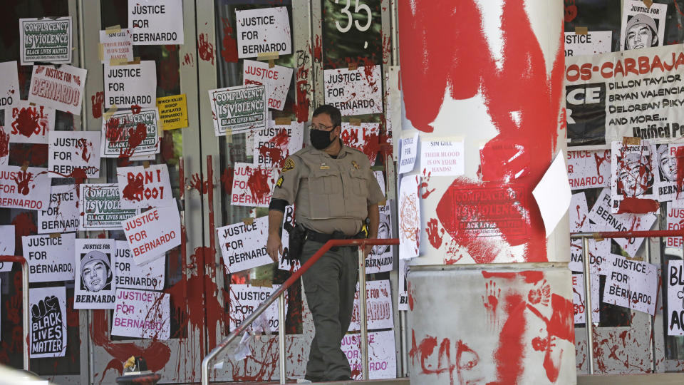 FILE - In this July 10, 2020, file photo, a Salt Lake County Sheriff walks in front of the district attorney's office in Salt Lake City. Some Black Lives Matter protesters in Utah could face up to life in prison if they're convicted of splashing red paint and smashing windows during a protest, a potential punishment that stands out among demonstrators arrested around the country and one that critics say doesn't fit the alleged crime. (AP Photo/Rick Bowmer, File)