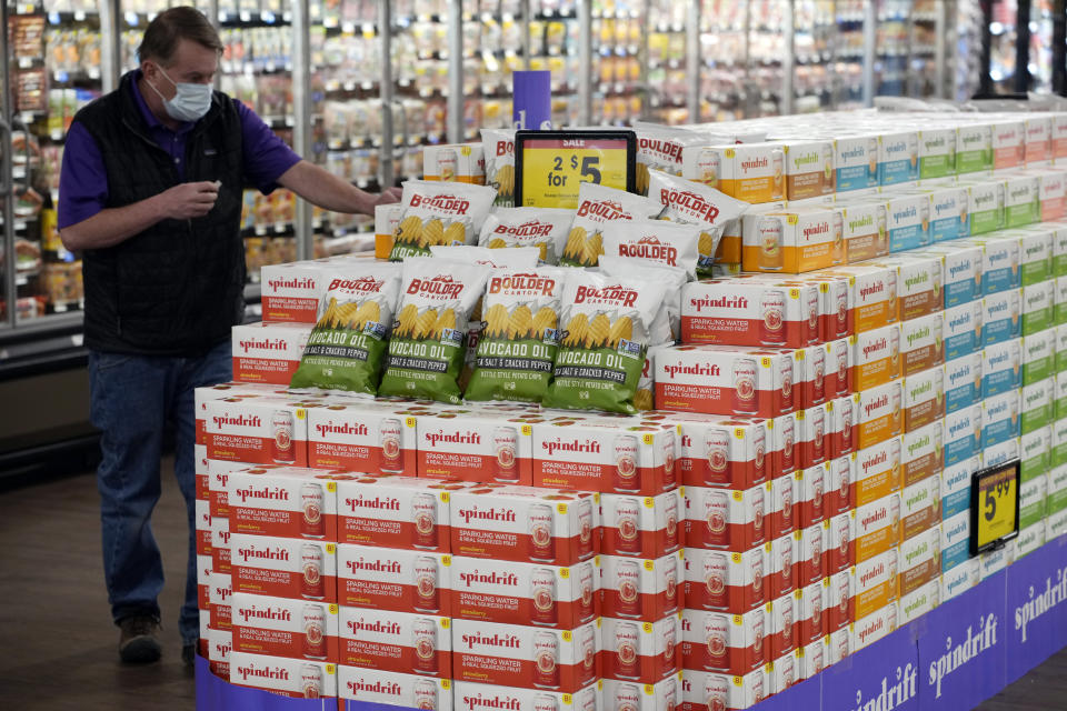A worker stocks a display of chips and soda in the Table Mesa King Soopers during a media tour Tuesday, Feb. 8, 2022, in Boulder, Colo. Ten people were killed inside and outside the store when a gunman opened fire on March 22, 2021. The store reopens with new renovations on Wednesday, Feb. 9. (AP Photo/David Zalubowski)