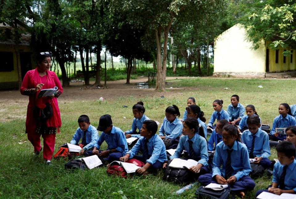 Resham’s lesson is taken outdoors because the fan in the classroom is broken (Reuters)