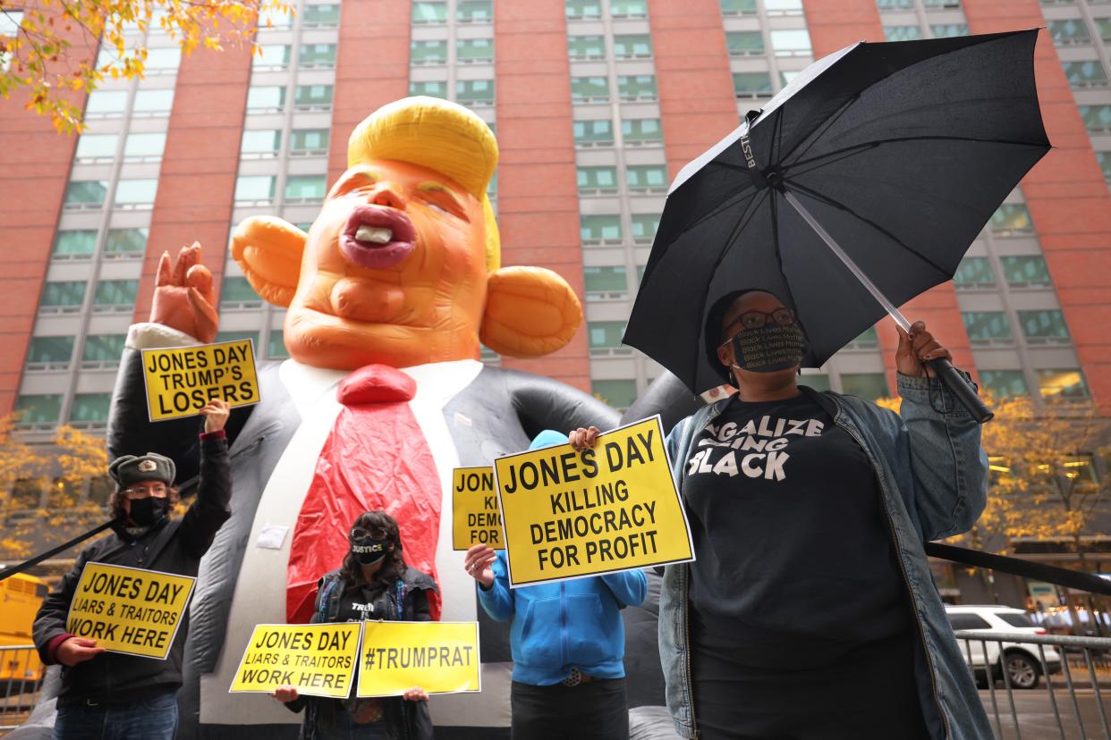 Demonstrators hold up signs in front of an inflatable giant rat in the likeness of U. S. President Donald Trump outside the NYC office of Jones Day law Firm on November 13, 2020 in New York City. The Jones Day Law firm is representing U.S. President Donald Trump and the Republican party in challenging the results of the 2020 presidential elections.   (Photo by Michael M. Santiago/Getty Images) (Getty Images)