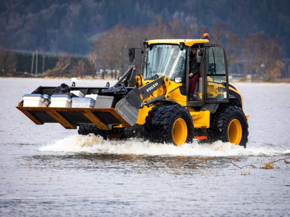 A loader moves property to dry land in the Sumas Prairie flood zone in Abbotsford in late November. City council has approved a plan that would significantly overhaul the flood mitigation infrastructure in the Fraser Valley city. (Ben Nelms/CBC - image credit)