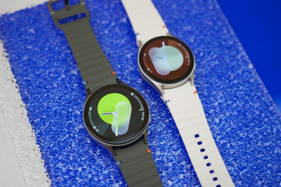 Two Samsung Galaxy Watch 7 smartwatches laying next to each other on a table.