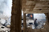 <p>TOPSHOT – A Syrian man walks amid the rubble of destroyed buildings following reported government airstrike on the rebel-held town of Douma, on the eastern outskirts of the capital Damascus, on February 26, 2017.<br> Government raids continue despite the United Nations confirmation a few days earlier that Moscow formally asked its ally Damascus to stop launching strikes during the Geneva negotiations, which began earlier in the week. / AFP / Abd Doumany (Photo credit should read ABD DOUMANY/AFP/Getty Images) </p>