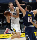 Utah Jazz forward Bojan Bogdanovic, left, passes the ball as he drives by Denver Nuggets center Nikola Jokic in the first half of an NBA basketball game Sunday, Jan. 17, 2021, in Denver. (AP Photo/David Zalubowski)