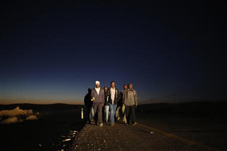 African migrants walk on a road after abandoning a detention facility in the southern Israeli desert December 15, 2013. REUTERS/Amir Cohen