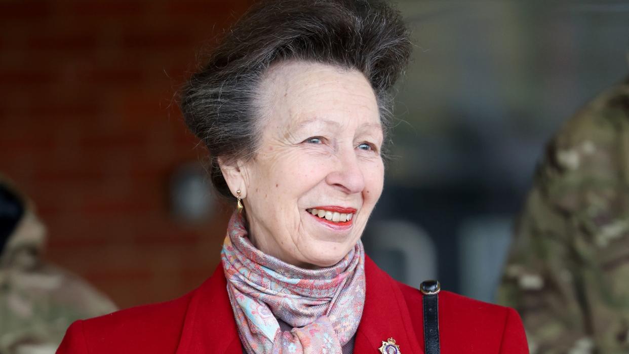 Princess Anne smiling and wearing red jacket