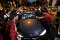 Journalists surround a car carrying U.S. Olympic swimmers Jack Conger and Gunnar Bentz as they leave a police station after being questioned in Rio de Janeiro, August 18, 2016. REUTERS/Bruno Kelly