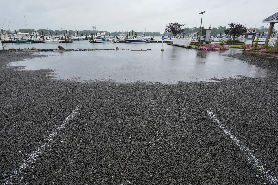 The parking lot of a marina starts to flood during high tide, Sunday, Aug. 22, 2021, in Branford, Conn., as Tropical Storm Henri affects the Atlantic coast. (AP Photo/Mary Altaffer)