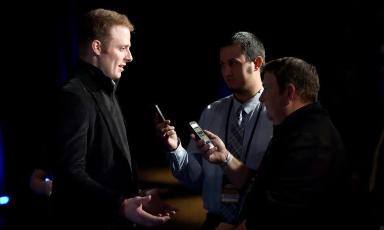 Greg McElroy speaks with reporters at an event.