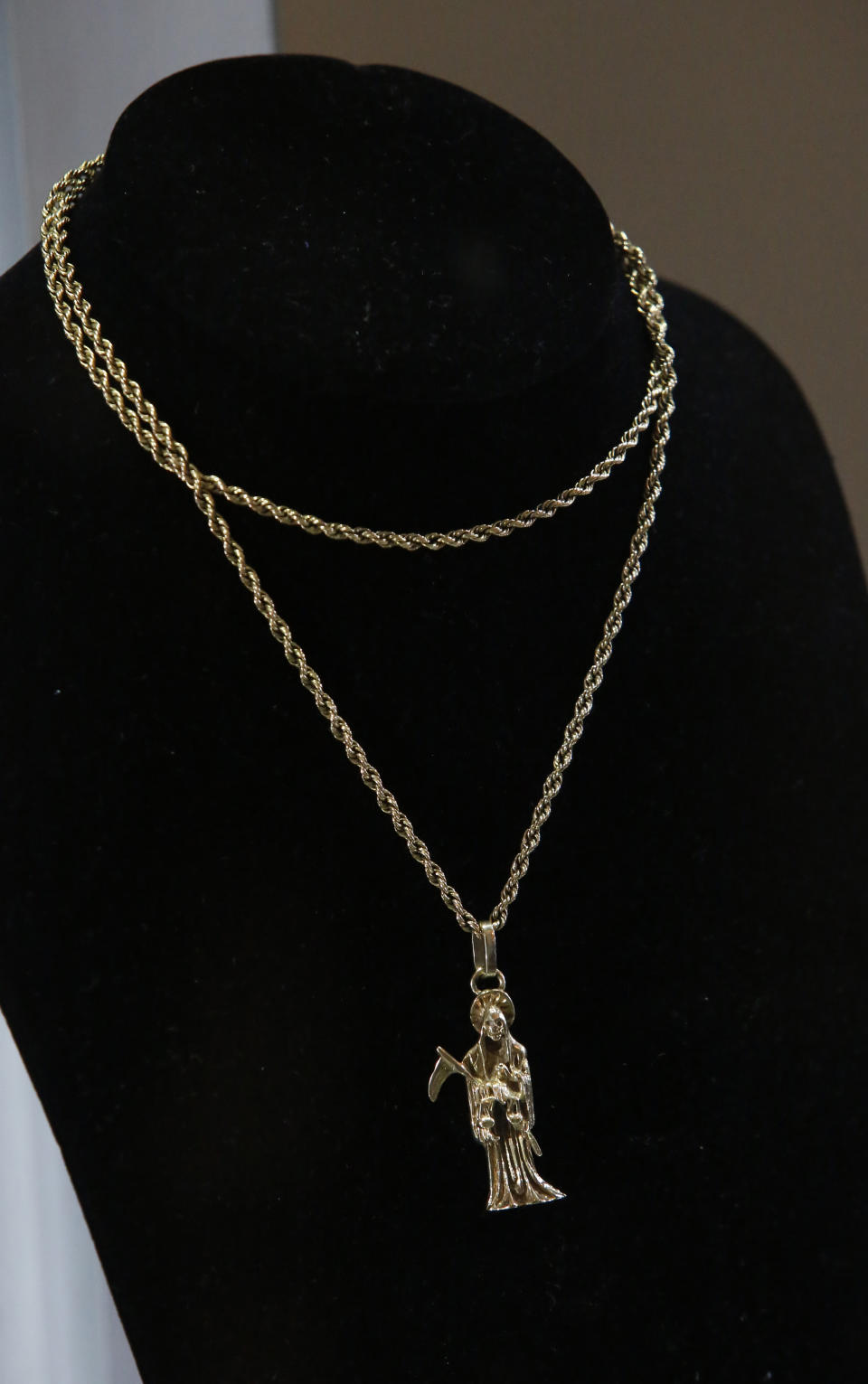 A necklace made of white gold with a pendant in the image of "Holy Death" is on display only during an auction of government seized jewelry at Los Pinos Cultural Center, formerly the presidential residence, in Mexico City, Sunday, July 28, 2019. This necklace was removed from the auction due to the image it represents and was only displayed. (AP Photo/Ginnette Riquelme)