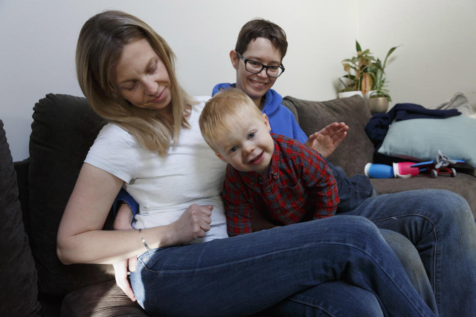 In this Friday, Nov. 16, 2018, photo, Anna Ford, left, and her partner, Sara Watson, play with their son Eli at home in the village of Saunderstown, in Narragansett, R.I. Three years after the landmark U.S. Supreme Court case that gave same-sex couples the right to marry nationwide, a patchwork of outdated state laws governing who can be a legal parent presents obstacles for many LGBTQ couples who start a family, lawyers say. (AP Photo/Michael Dwyer)