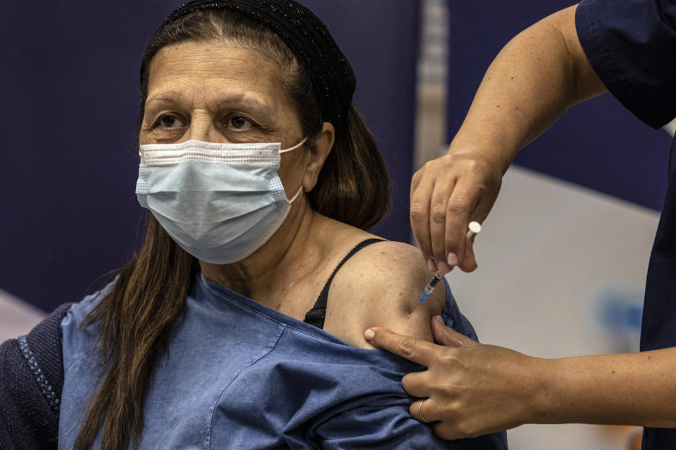 Malka Peer receives the fourth dose of the Pfizer-BioNTech COVID-19 vaccine at the Sheba Medical Center in Ramat Gan, Israel, Friday, Dec. 31, 2021. (AP Photo/Tsafrir Abayov)