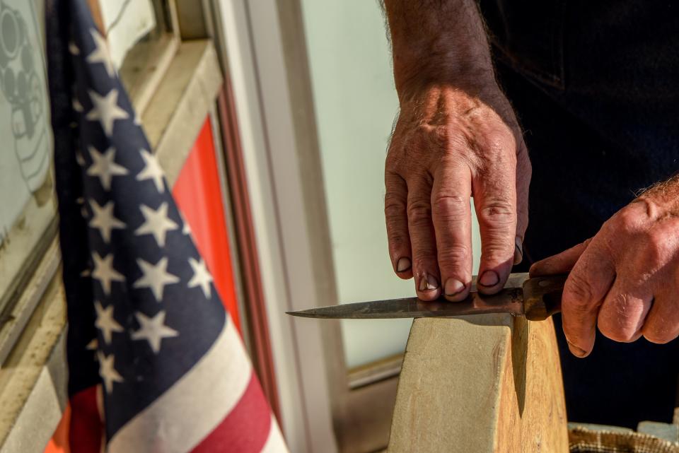 Dave Feinberg, the owner of Cutter's Edge in Clifton recently removed a sign from his store window that inflamed social media. The sign read "Speak English or Pay $10 Extra." Feinerg holds a knife against a sahrpening stone on Tuesday September 8, 2020. 