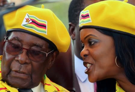 FILE PHOTO: President Robert Mugabe listens to his wife Grace Mugabe at a rally of his ruling ZANU-PF party in Harare