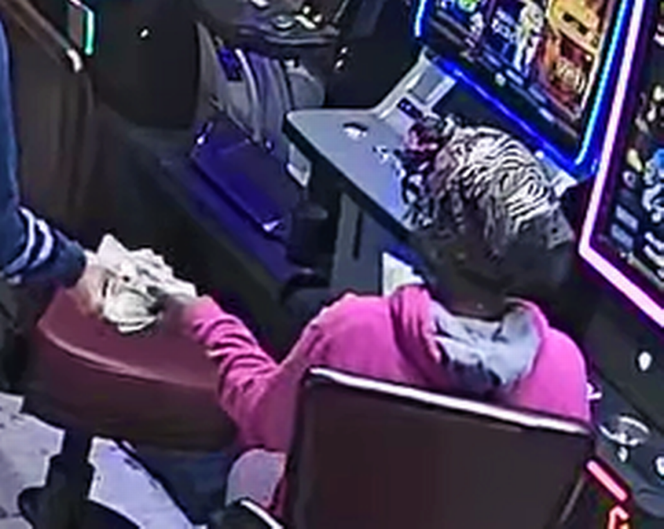 Lakiesha Deshawn McGhee shown here handing over cash to an armed bandit in surveillance footage of a Jan. 18 armed robbery at a Warner Robins-area lottery and video poker shop.