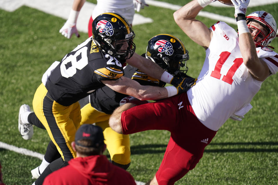 Nebraska tight end Austin Allen (11) catches a pass over Iowa defensive back Jack Koerner (28) during the first half of an NCAA college football game, Friday, Nov. 27, 2020, in Iowa City, Iowa. (AP Photo/Charlie Neibergall)