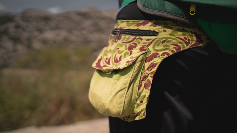 Detail of the fanny pack of a hiker during a trail in the mountains