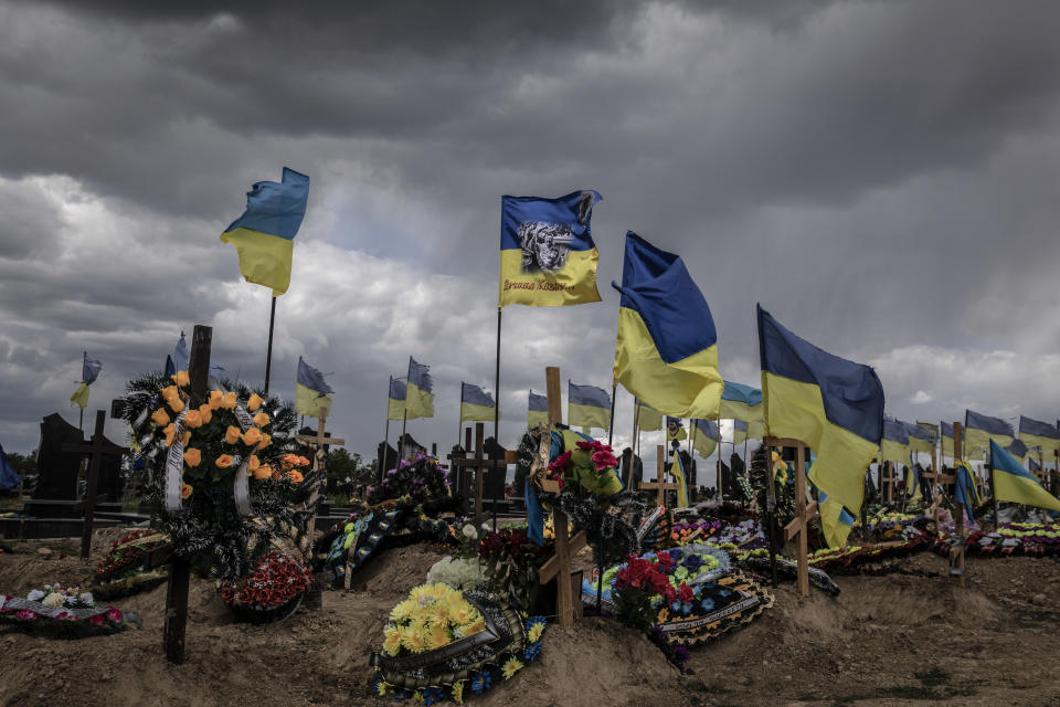 Banderas ucranianas ondean sobre las tumbas en el cementerio militar de Járkov, Ucrania, el 17 de mayo de 2022. (Finbarr O'Reilly/The New York Times)
