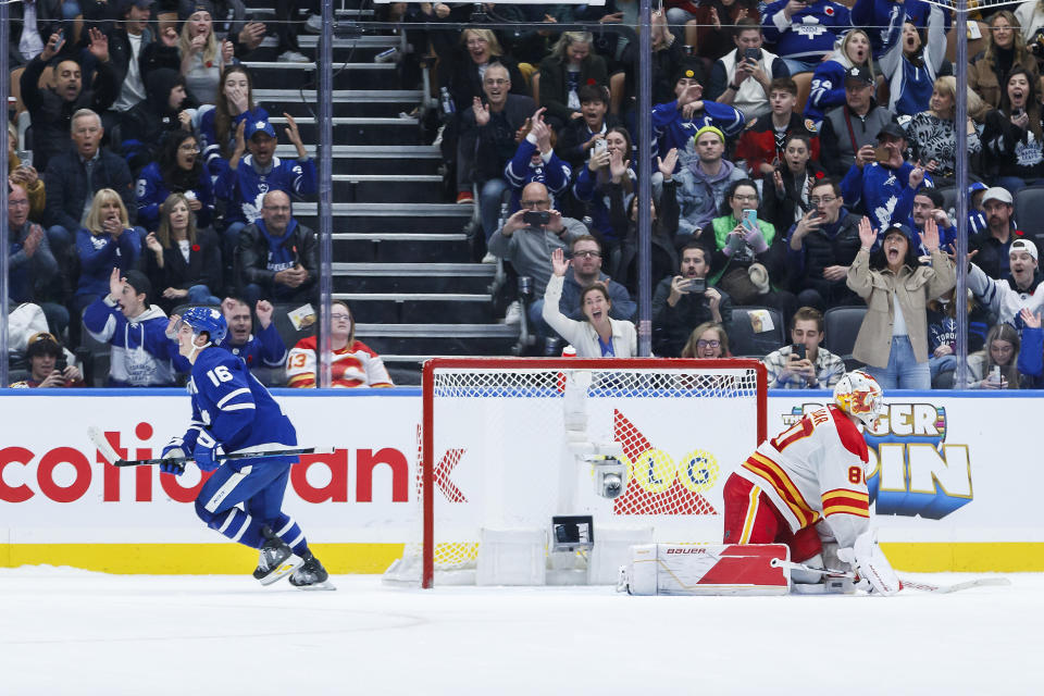 Toronto Maple Leafs right wing Mitchell Marner (16) skates away from Calgary Flames goaltender Dan Vladar (80) after scoring during the shootout in an NHL hockey game Friday, Nov. 10, 2023, in Toronto. (Cole Burston/The Canadian Press via AP)