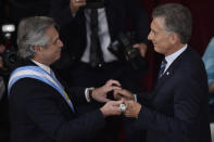 El nuevo presidente de Argentina, Alberto Fernández, a la izquierda, recibe el bastón presidencial del presidente saliente Mauricio Macri en el Congreso en Buenos Aires, Argentina, el martes 10 de diciembre de 2019. (AP Foto / Gustavo Garello)