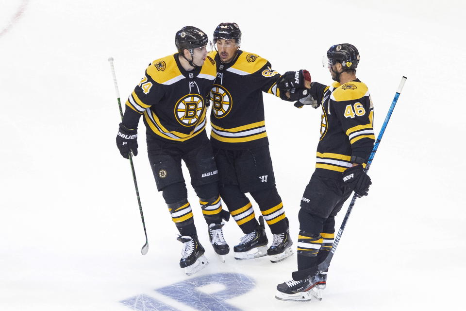 Boston Bruins' David Krejci (46) celebrates his goal against the Carolina Hurricanes with teammates Jake DeBrusk (74) and Brad Marchand (63) during the first period of an NHL Eastern Conference Stanley Cup hockey playoff game in Toronto, Thursday, Aug. 13, 2020. (Chris Young/The Canadian Press via AP)