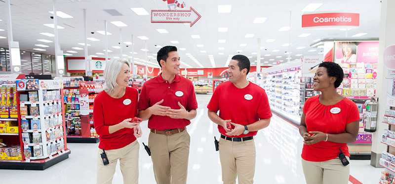 Target employees happily chat in an aisle.