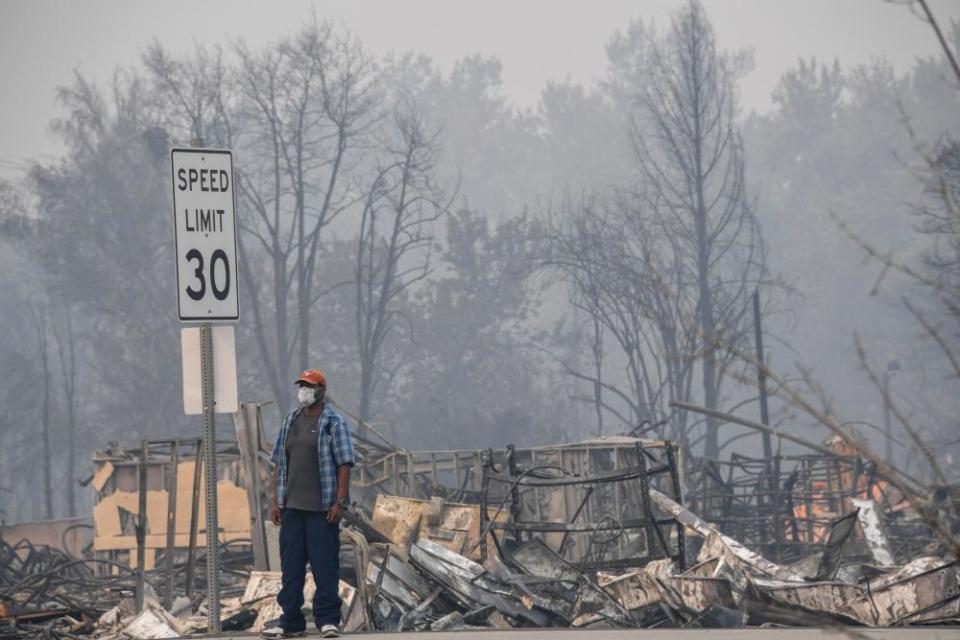 A man stands near some of the destruction caused by the Almeda Fire in Phoenix, Oregon, September 15, 2020.