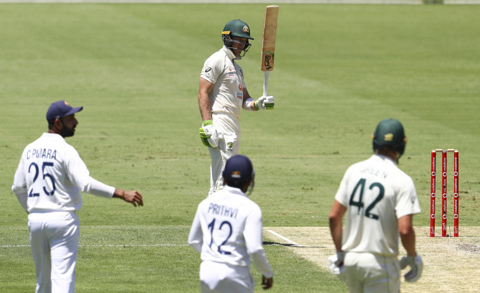 Australia's Tim Paine gestures with his bat on reaching 50 runs during play on day two of the fourth cricket test between India and Australia at the Gabba, Brisbane, Australia, Saturday, Jan. 16, 2021. (AP Photo/Tertius Pickard)