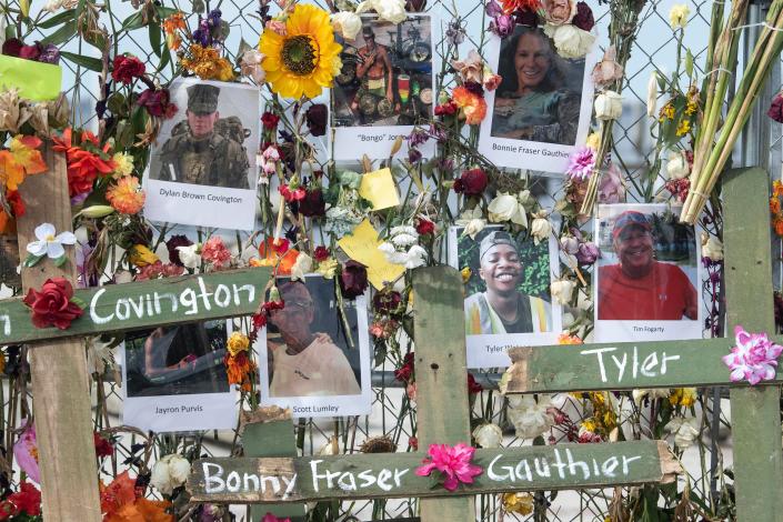 Photographs of Hurricane Ian victims cover a wall of flowers that make up the Hurricane Ian memorial at Centennial Park on Sunday, October 9, 2022 in Fort Myers, Fla. The memorial was started by Leo Soto and the crosses, bearing the victim's names, were added by Roberto Marquez. 