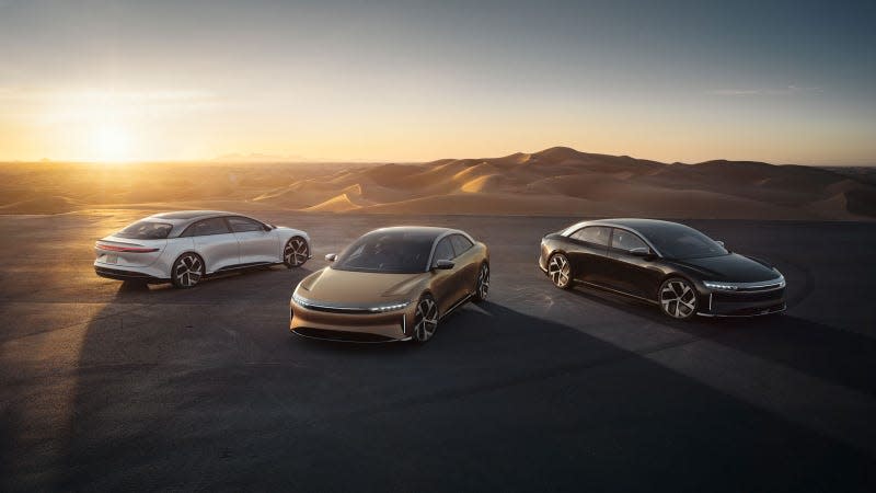 A photo of three Lucid Air sedans at sunset. 