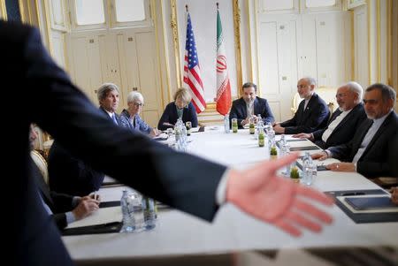 A security personnel asks reporters to leave a room where U.S. Secretary of State John Kerry (L) is meeting with Iranian Foreign Minister Mohammad Javad Zarif (2nd R) at a hotel in Vienna, Austria July 1, 2015. REUTERS/Carlos Barria