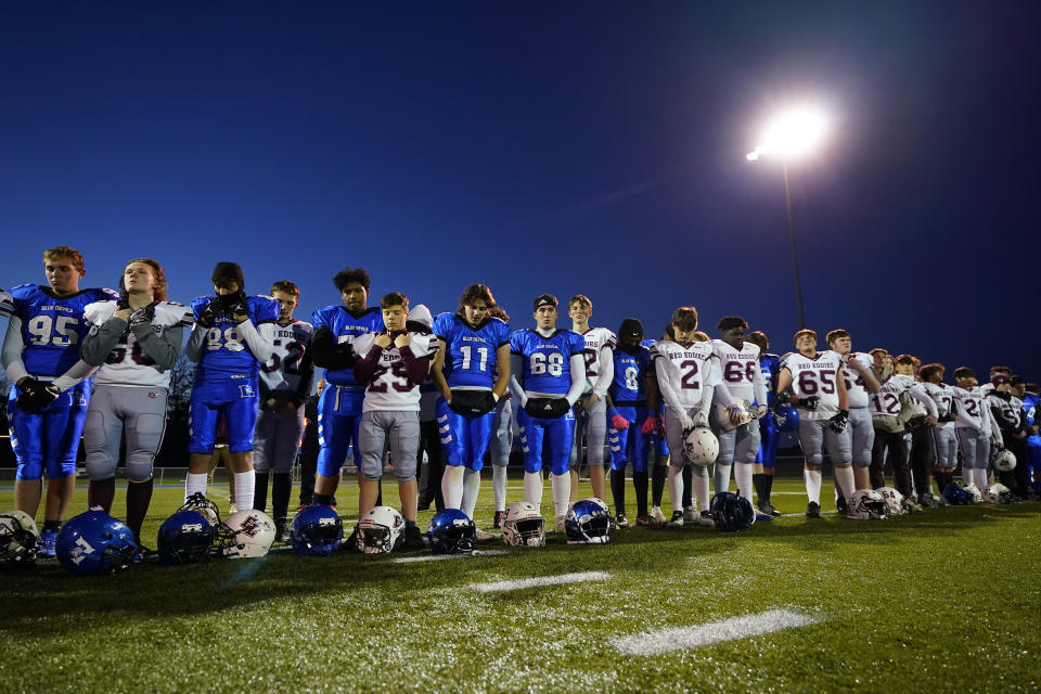 Lewiston High School and Edward Little High School players stand together, Wednesday, Nov. 1, 2023, prior to their high school football game in Lewiston, Maine. Locals seek a return to normalcy after a mass shooting on Oct. 25. (AP Photo/Matt York)