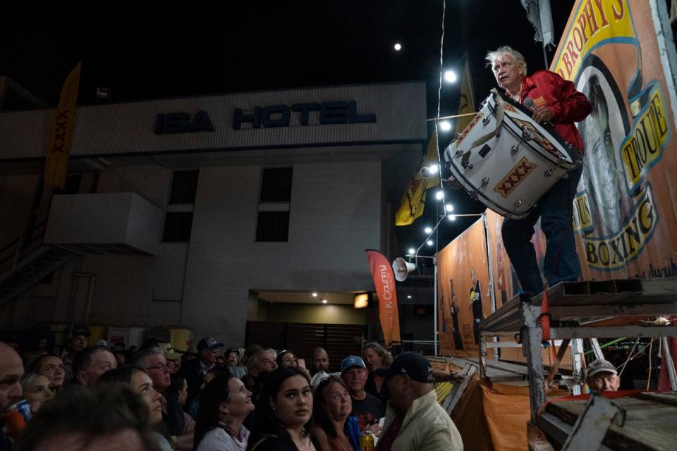 The ‘spruiker’ bangs a drum, announcing his boxers for the night (Washington Post photo by Michael Robinson Chavez)