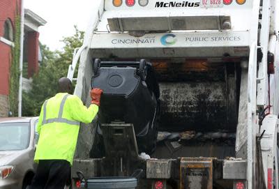 A Cincinnati employee collects trash in Avondale. The Cincinnati Futures Commission has recommended the city begin collecting a monthy trash fee.