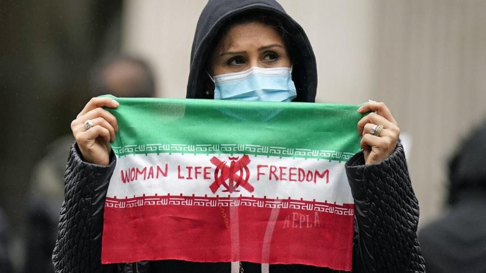 Woman holds protest sign at Trafalgar Square, London (29/10/22)