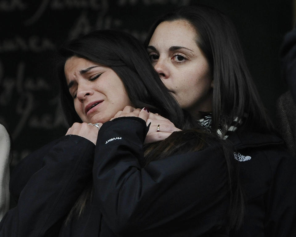 Erica Lafferty, daughter of Sandy Hook Elementary School shooting victim, Dawn Hochsprung, right, consoles Carlee Soto, sister of victim Victoria Soto after families representing fourteen families addressed the media, Monday, Dec. 9, 2013, in Newtown, Conn. Newtown is not hosting formal events to mark the anniversary Saturday. (AP Photo/Jessica Hill)