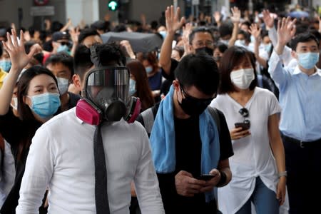 Anti-government office workers wearing masks attend a lunch time protest, after local media reported on an expected ban on face masks under emergency law, at Central, in Hong Kong